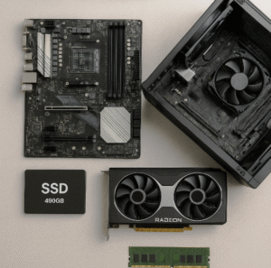 Componentes de computador sobre a mesa, incluindo placa-mãe, gabinete, SSD, placa de vídeo e memória RAM.